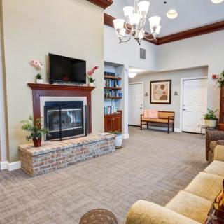 Cozy living room with a fireplace, chandelier, and comfortable seating.