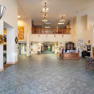 A spacious hotel lobby with a reception desk and seating area.