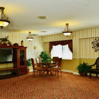 A cozy living room with traditional furniture, a dining table, and indoor plants.
