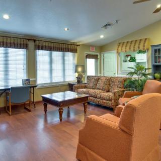 A cozy living room with comfortable seating, large windows, and hardwood flooring.