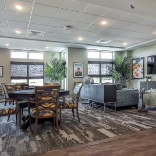 A modern living room and dining area with ample natural light and stylish furniture.
