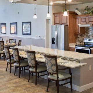 A spacious kitchen and dining area with a long countertop and elegant seating.