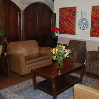 A cozy living room featuring comfortable seating, a decorative coffee table, and vibrant artwork.