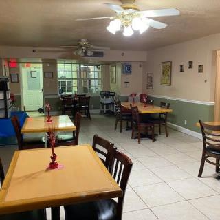 An empty restaurant dining area with neatly arranged tables and chairs.