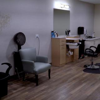 A modern salon interior featuring chairs, mirrors, and hair styling equipment.