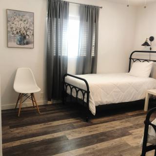 A minimalist bedroom with a single bed and modern decor.
