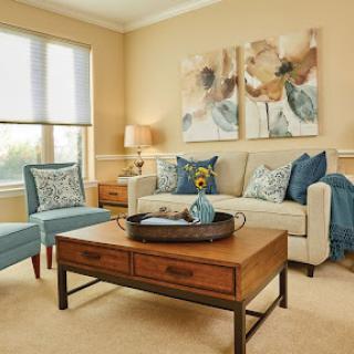 A cozy and elegantly designed living room featuring a stylish sofa, accent chairs, and tasteful artwork.
