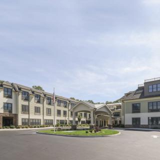 A well-maintained hotel or residential building with landscaped surroundings.