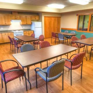 A communal space with tables and chairs, suitable for dining or meetings.