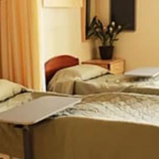 A hospital room with two beds and bedside tables.