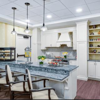 A modern kitchen featuring a central island with pendant lighting and white cabinetry.