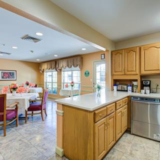A cozy kitchen and dining area with wooden cabinets, a countertop, and modern appliances.