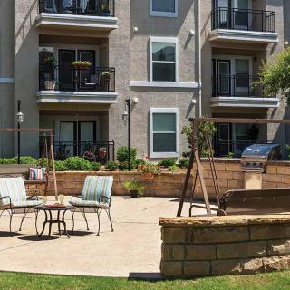 Outdoor patio area with seating in front of an apartment building.