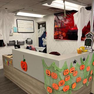 Office reception area decorated with Halloween-themed pumpkins and ghosts.