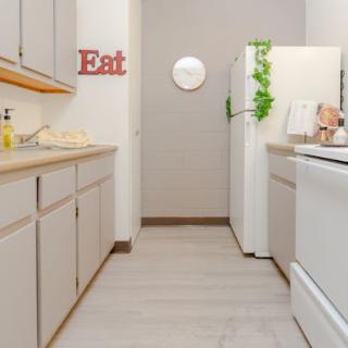 A bright and modern kitchen featuring white cabinetry and essential appliances.