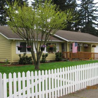 Suburban house with a white picket fence and American flag.