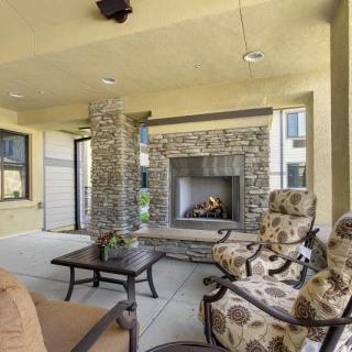 A cozy outdoor patio with a stone fireplace and comfortable seating.