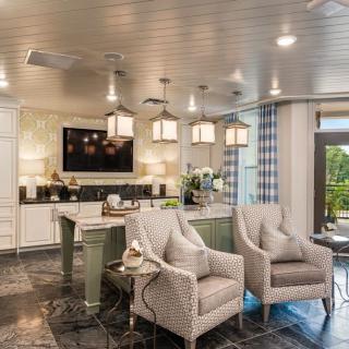 A modern kitchen with an open living area, featuring stylish furnishings and contemporary lighting.