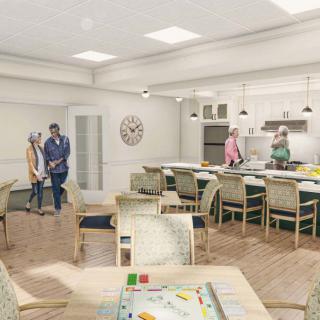 A spacious community kitchen and dining area with people interacting and preparing food.