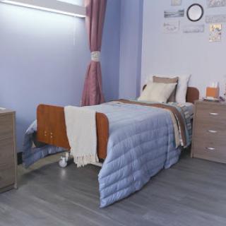 A well-furnished hospital room featuring a bed, nightstand, and decorative elements.