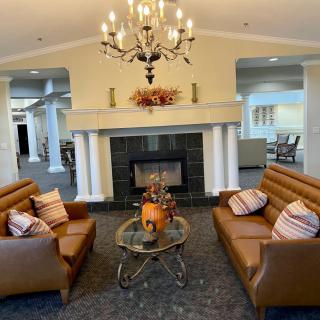A cozy living room with elegant furnishings and a central fireplace.