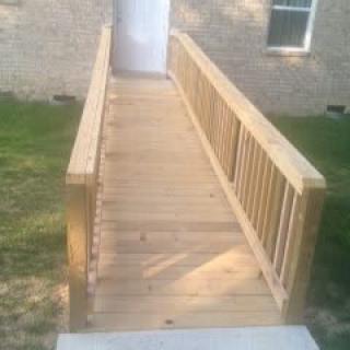 A wooden accessibility ramp leading to a building entrance.