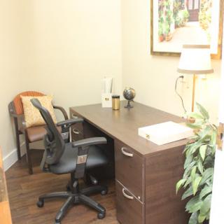 A cozy office space with a desk, ergonomic chair, and decorative elements.