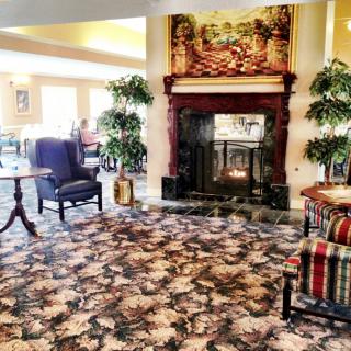 A cozy lobby area featuring a fireplace, comfortable seating, and elegant decor.