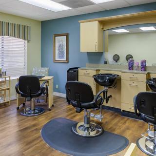An empty hair salon with modern styling chairs and mirrors.