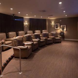A cozy home theater with recliner chairs and soft lighting.