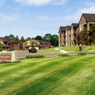 A well-maintained suburban apartment complex with lush green lawns and multiple buildings.