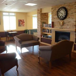 A cozy living room with comfortable seating, a fireplace, and bookshelves.
