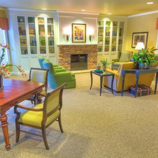 A cozy living room featuring a fireplace, comfortable seating, and bookshelves filled with decor.