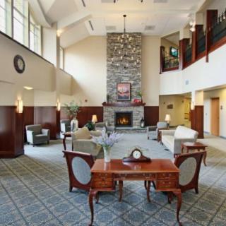 Spacious lobby with a comfortable seating area, featuring a central fireplace and elegant furniture.