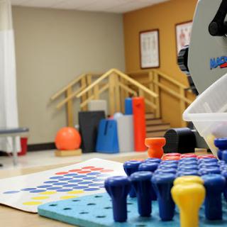 A well-equipped therapy room featuring colorful tools for rehabilitation and sensory activities.