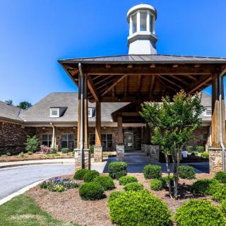 A beautifully designed building entrance with landscaped gardens under a clear blue sky.