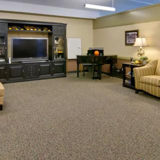 A cozy living room with comfortable seating, a large television, and warm lighting.