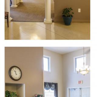 A spacious lobby area with a clock, chandelier, and decorative plants.