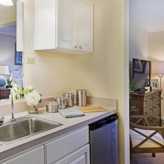 A cozy apartment kitchen with a stainless steel sink and modern decor.