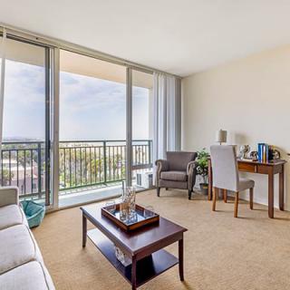 Bright living room with a view of the balcony and comfortable furnishings.
