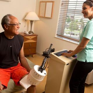 A patient undergoing physical therapy with the assistance of a healthcare professional and specialized equipment.