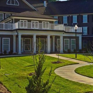 A beautiful residential house with a well-maintained lawn and curved pathway.