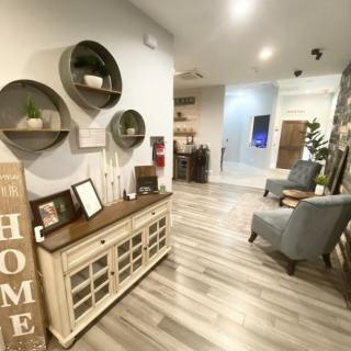 A cozy and modern living room interior with stylish decor, featuring armchairs, a console table, and wall-mounted shelves.