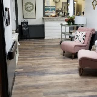 A cozy living room featuring elegant pink chairs and wooden flooring, exuding warmth and style.