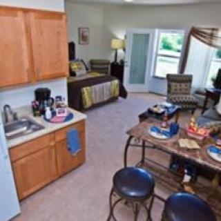 A cozy studio apartment featuring a compact kitchen and a comfortable living area.