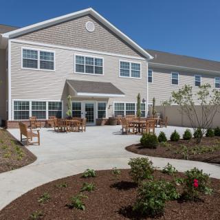 A residential building with a landscaped garden and outdoor seating area.