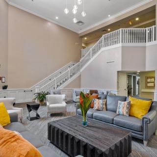 A modern living room featuring comfortable seating and a staircase.