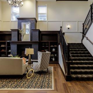 Elegant living room with a staircase and cozy seating area.