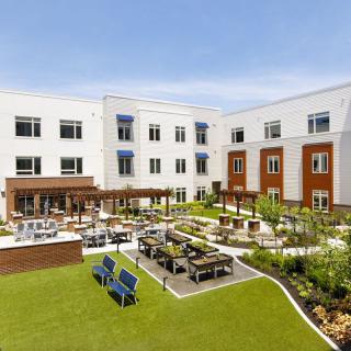 A modern building with a landscaped courtyard featuring outdoor seating and gardens.