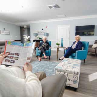 A cozy living room setting with people relaxing and reading.